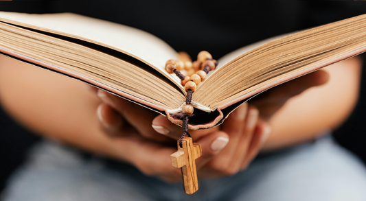 Person holding a bible with cross chain bookmark.