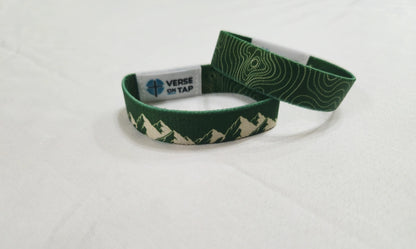 Green wristband with mountain design and Verse On Tap label on a white background, reverse side has Topography lines.