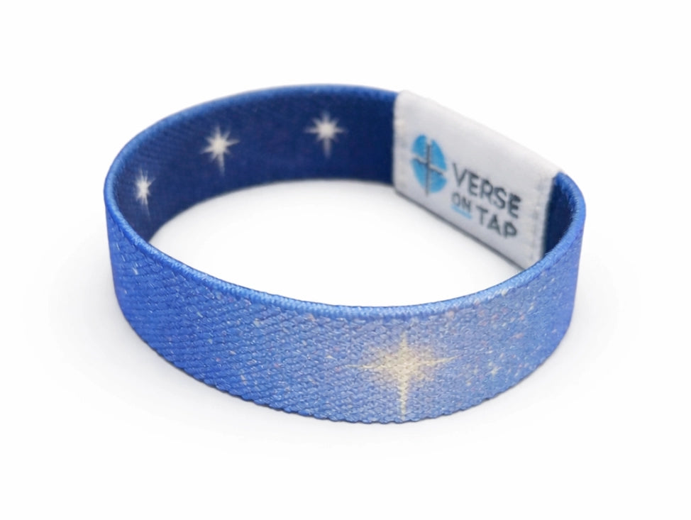 Blue wristband with star patterns and a label on a white background