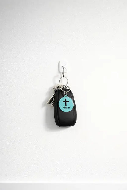 NFC keychain shown on a set of keys. Teal NFC keychain with black cross and "FAITH" black text.